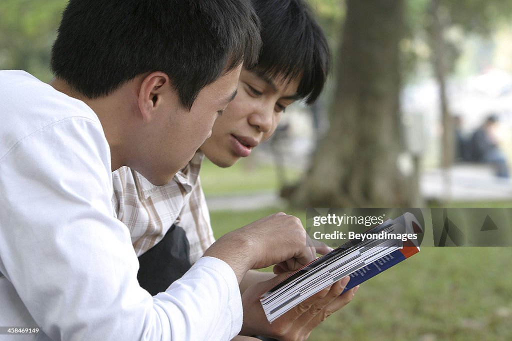 Two students reading guidebook