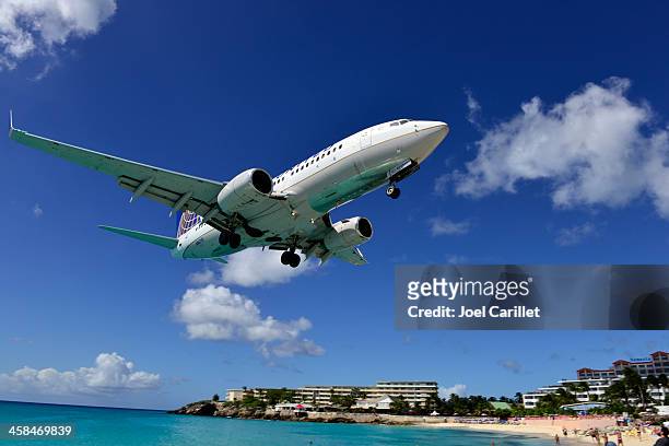 united airlines landing in st. maarten - maho beach stock pictures, royalty-free photos & images