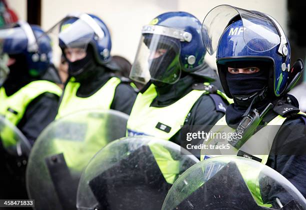 london bereitschaftspolizist überwachung der situation. - police in riot gear stock-fotos und bilder