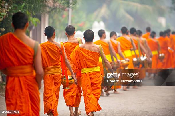 group of monks walking in street, laung prabang, laos - theravada stock pictures, royalty-free photos & images
