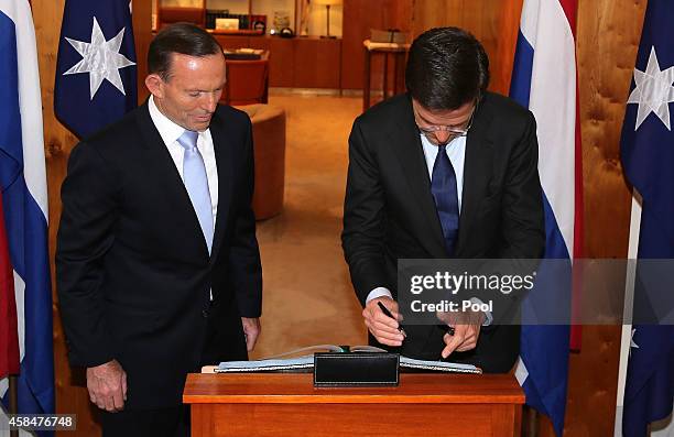Prime Minister of the Netherlands Mark Rutte signs the visitor's book after he was greeted by Australia's Prime Minister Tony Abbott at Parliament...