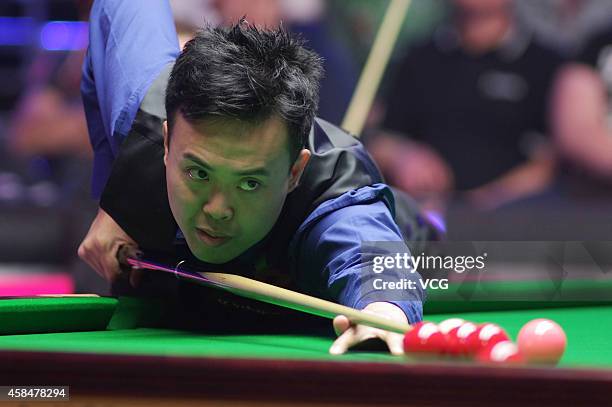 Marco Fu of China plays a shot against Shaun Murphy of England during their 1/8 match on day three of the 2014 Dafabet Champion of Champions at The...