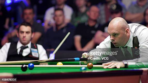 Stuart Bingham of England plays a shot against Ronnie O'Sullivan of England during their 1/8 match on day three of 2014 Dafabet Champion of Champions...