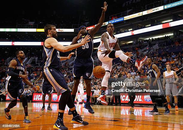 Eric Bledsoe of the Phoenix Suns passes the ball around Zach Randolph and Marc Gasol of the Memphis Grizzlies during the first half of the NBA game...