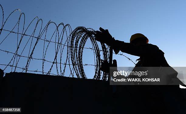 To go with Afghanistan-unrest-US-Bagram,FEATURE by Emmanuel PARISSE In this photograph taken on November 1 a US soldier removes barbed wire from a...