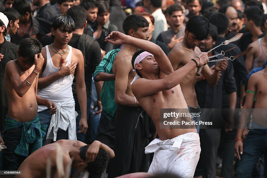 Indian Shiite Muslims flagellate themselves during an Ashura...