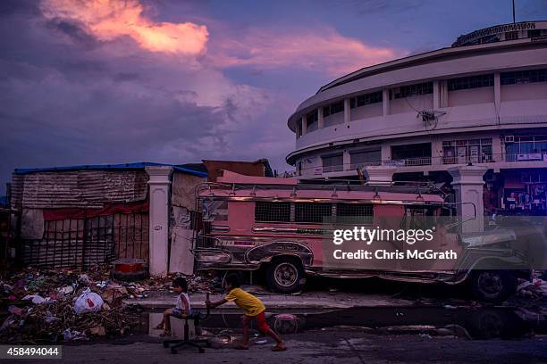 Children play on the street in front of the Tacloban Astrodome evacuation center following the recent super typhoon on November 20, 2013 in Leyte,...