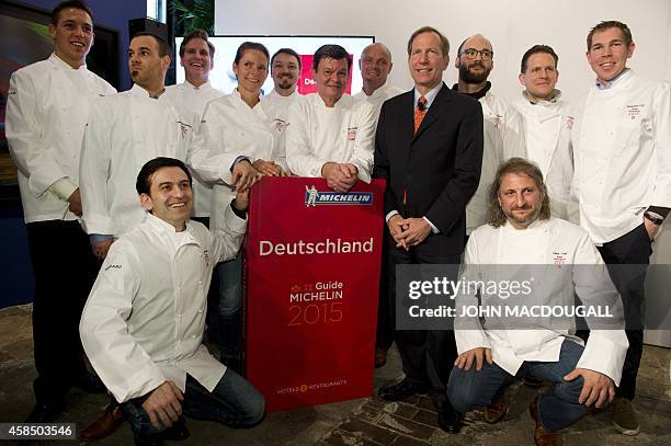 International Michelin Guide Director Michael Ellis and senior German chef Harald Wohlfahrt pose with newly induced chefs during the official launch...