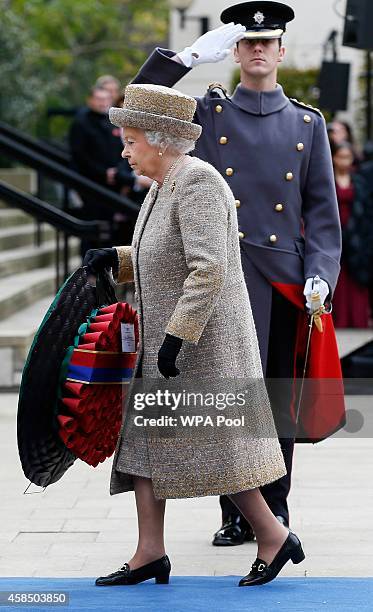 Queen Elizabeth II holds a wreath during the Opening of the Flanders' Fields Memorial Garden at Wellington Barracks on November 6, 2014 in London,...