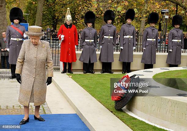 Queen Elizabeth II places a wreath of poppies at the new Flanders Field Memorial outside the Guards Chapel on November 6, 2014 in London, England.