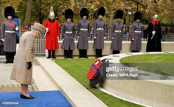 Queen Elizabeth II places a wreath of poppies at the new Flanders Field Memorial outside the Guards Chapel on November 6, 2014 in London, England.