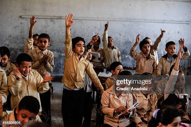 Egyptian students are seen during a lesson at the class of a primary school, where nearly 2 thousand students get education, in Baragil neighborhood...