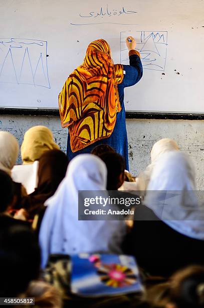 Egyptian students and teacher are seen during a lesson at the class of a primary school, where nearly 2 thousand students get education, in Baragil...