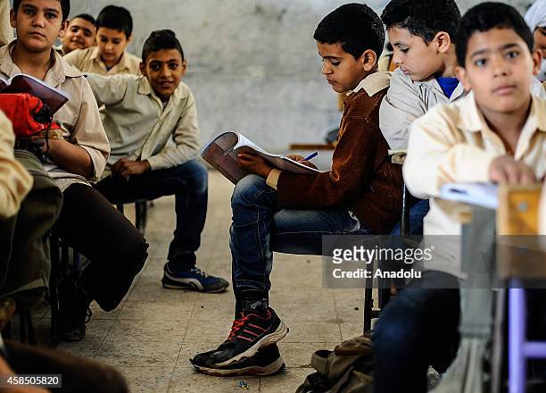 Egyptian students are seen during a lesson at the class of a primary school, where nearly 2 thousand students get education, in Baragil neighborhood...