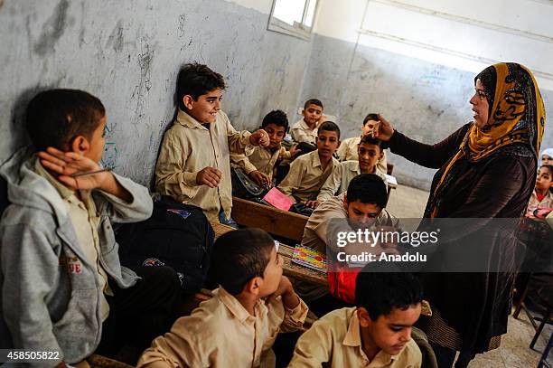 An Egyptian student is punished by his teacher during the lesson at a primary school, where nearly 2 thousand students get education, after the...