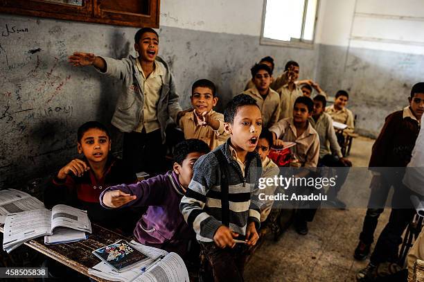 Egyptian students are seen during a lesson at the class of a primary school, where nearly 2 thousand students get education, in Baragil neighborhood...