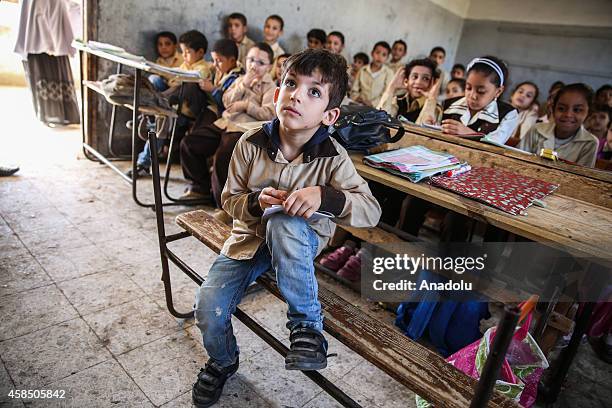 An Egyptian student sits on a broken desk during a lesson at the class of a primary school, where nearly 2 thousand students get education, in...