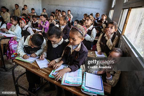 Egyptian students are seen during a lesson at the class of a primary school, where nearly 2 thousand students get education, in Baragil neighborhood...