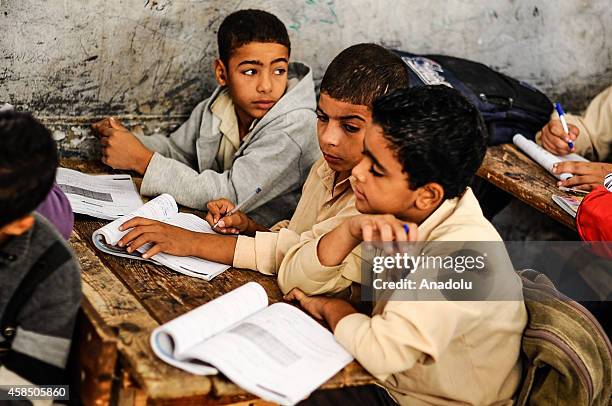 Egyptian students are seen during a lesson at the class of a primary school, where nearly 2 thousand students get education, in Baragil neighborhood...