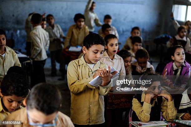 Egyptian students are seen during a lesson at the class of a primary school, where nearly 2 thousand students get education, in Baragil neighborhood...