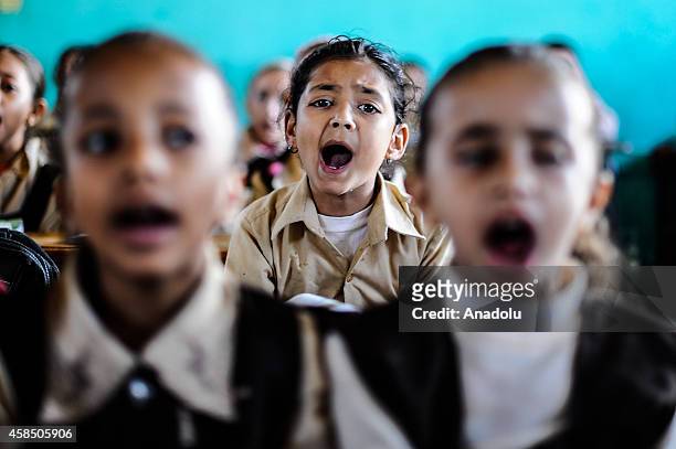 Egyptian students are seen during a lesson at the class of a primary school, where nearly 2 thousand students get education, in Baragil neighborhood...