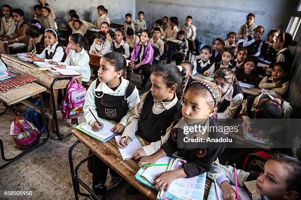 Egyptian students are seen during a lesson at the class of a primary school, where nearly 2 thousand students get education, in Baragil neighborhood...