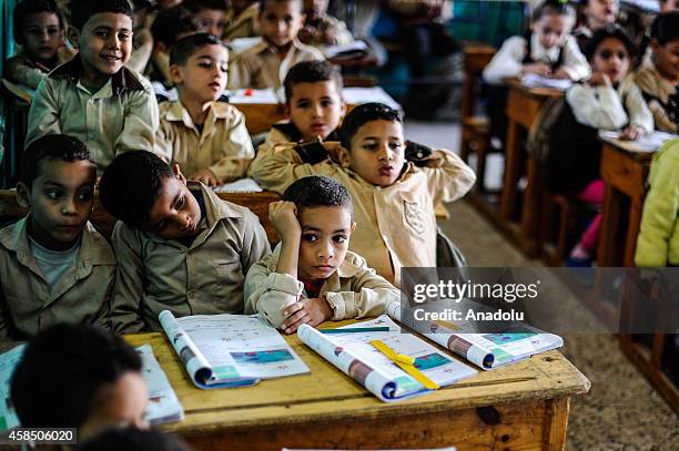 Egyptian students are seen during a lesson at the class of a primary school, where nearly 2 thousand students get education, in Baragil neighborhood...