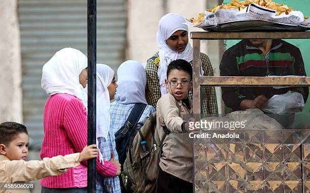 Egyptian students buy sandwiches from a pedlar near a primary school, where nearly 2 thousand students get education, in Baragil neighborhood of...