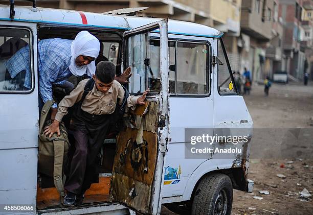 Egyptian students get off a school service at a primary school, where nearly 2 thousand students get education, in Baragil neighborhood of Giza,...