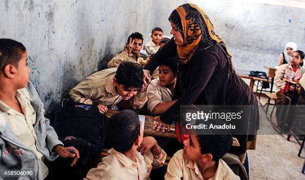 An Egyptian student is punished by his teacher during the lesson at a primary school, where nearly 2 thousand students get education, after the...