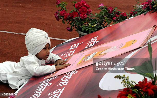 Child lies before the picture of Guru Nanak to pay his obeisance at Khalsa Stadium on the occasion of birth anniversary of Guru Nanak dev Ji on...