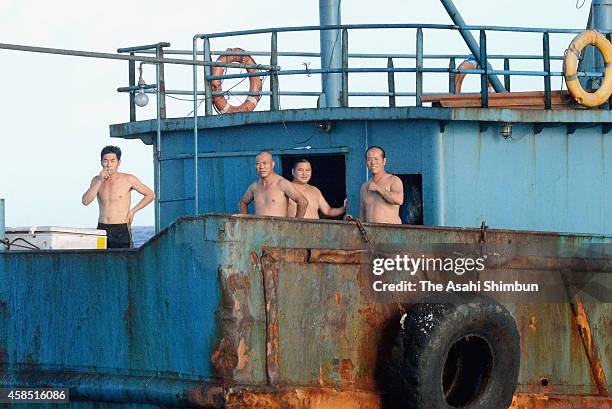 Crew members on a boat in waters near Chichijima island are seen as they appear to be coaching coral on November 2, 2014 in Ogasawara, Tokyo, Japan....