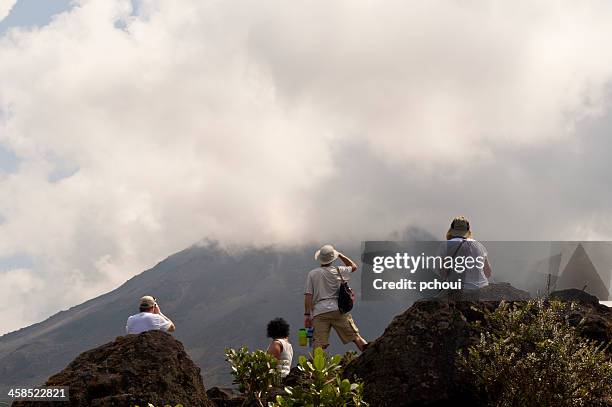 tourists looking at active arenal volcano in costa rica - costa rica volcano stock pictures, royalty-free photos & images