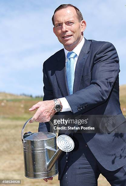 Australian Prime Minister Tony Abbott passes the watering can to Netherlands Prime Minister Mark Rutte while planting a silver birch tree at the...