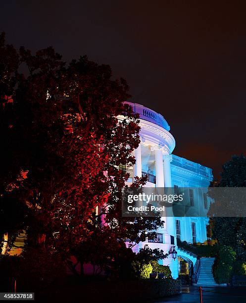 The White House is illuminated in red, white and blue lights to celebrate "A Salute to the Troops: In Performance at the White House" as seen from...