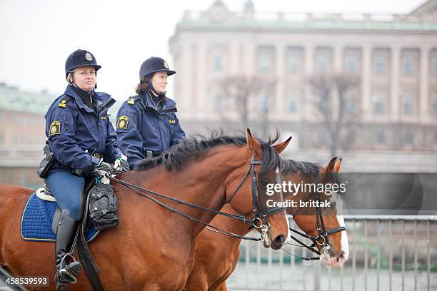 two female mounted police clearing the road. - bereden politie stockfoto's en -beelden