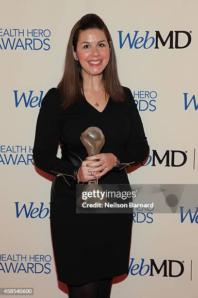 Of Research Engagement at the Michael J. Fox Foundation Claire Meunier poses with an award backstage at the 2014 Health Hero Awards hosted by WebMD...