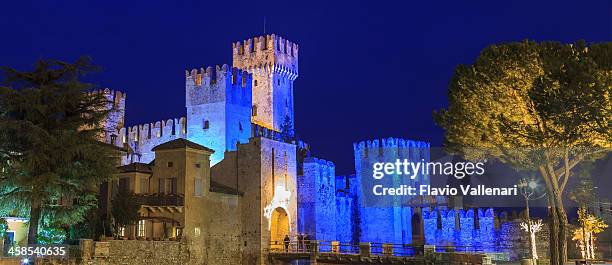 castillo iluminado en azul, sirmione, italia - sirmione fotografías e imágenes de stock