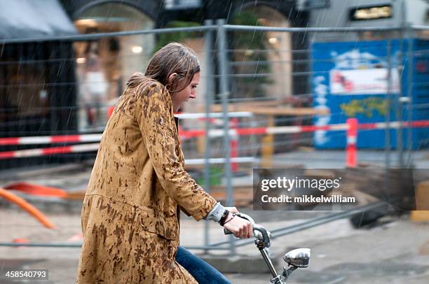 woman on a bicycle in pouring rain - drenched stock pictures, royalty-free photos & images