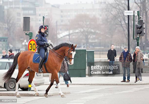 female mounted police clearing the road. - bereden politie stockfoto's en -beelden