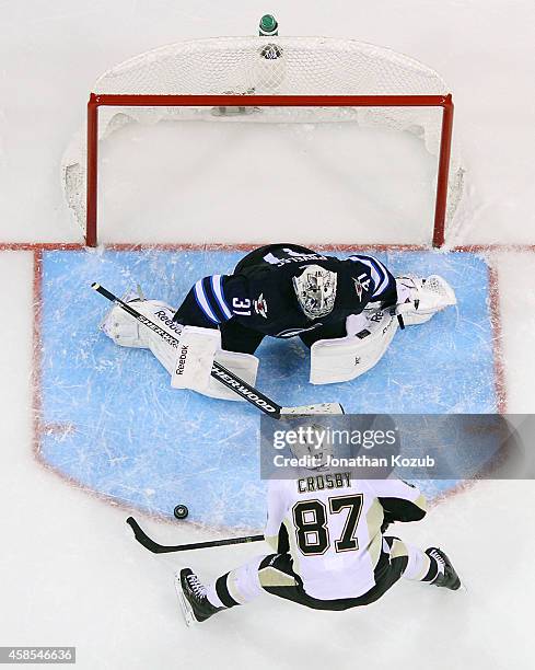 Sidney Crosby of the Pittsburgh Penguins skates the puck in on goaltender Ondrej Pavelec of the Winnipeg Jets during the shootout on November 6, 2014...