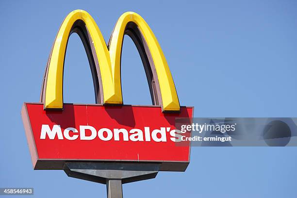 al aire libre, cerca de mcdonalds señal contra el cielo azul - mcdonalds fotografías e imágenes de stock