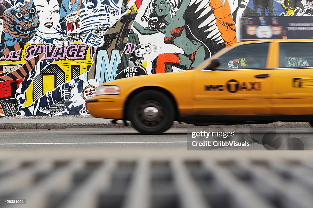 NYC yellow taxi and mural wall on Houston Street