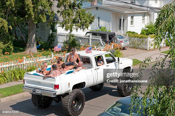 people riding in pick-up truck bed filled with water - hillbilly stock pictures, royalty-free photos & images