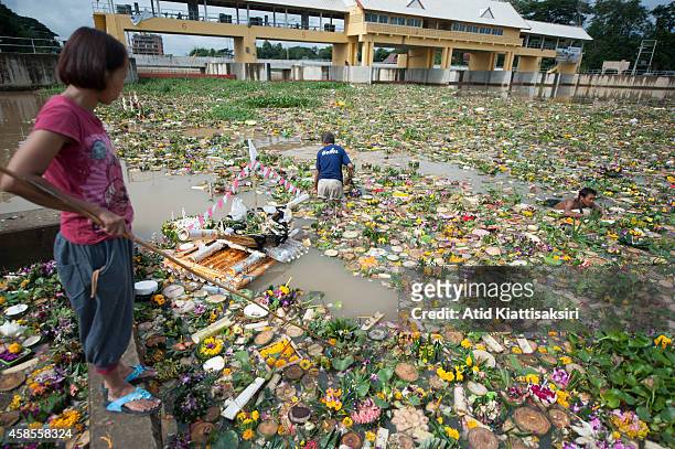 Thais find valuables from thousands of krathongs at a floodgate of the Ping river during the Loy Krathong Festival in Chiang Mai. People place money...