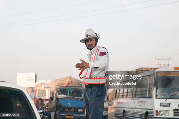 traffic police officer waving at cars in haryana, india - verkeerspolitie stockfoto's en -beelden
