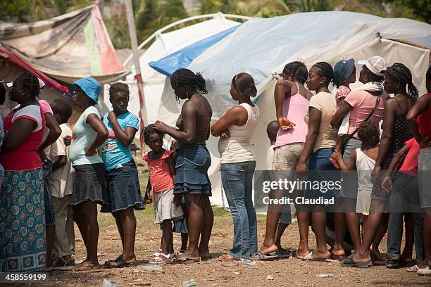 people in a refugee camp waiting for food - haiti poverty stock pictures, royalty-free photos & images