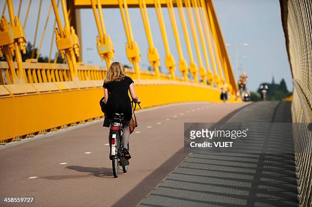 girl cycling on hogeweidebrug in utrecht - utrecht stock pictures, royalty-free photos & images