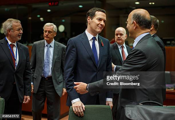 George Osborne, U.K. Chancellor of the exchequer, center, reacts while speaking to Pierre Moscovici, European Union Economic and Monetary Affairs...