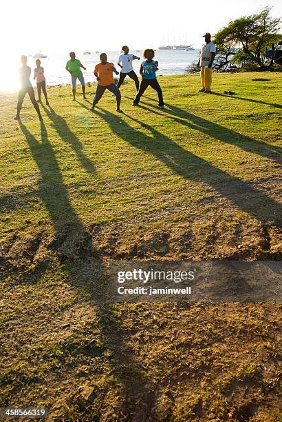 tai chi group practices fitness exercise on beach - tai chi shadow stock pictures, royalty-free photos & images